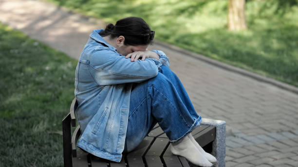 istock Depressed woman sitting on bench cries from loneliness 1505369677