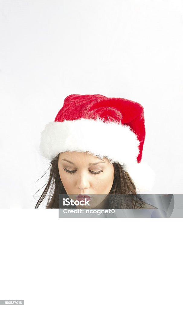 Woman looking at white paper Pretty lady wearing a Santa hat Adult Stock Photo