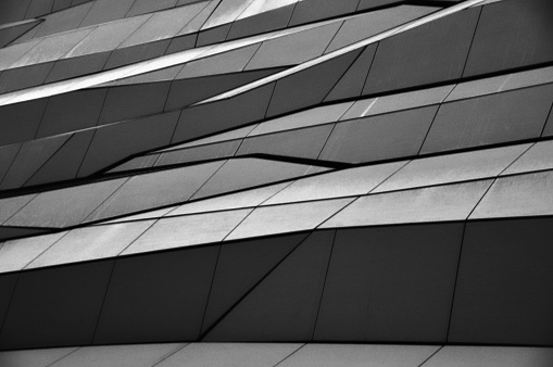 Modern building facade composed of panels and uneven monochromatic parts