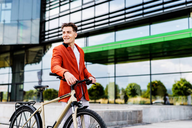 istock Smiling young man with bicycle walking by modern building 1505382881