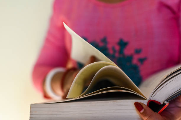 istock Unrecognizable person reading a book. Selective focus, book close-up. 1505383952