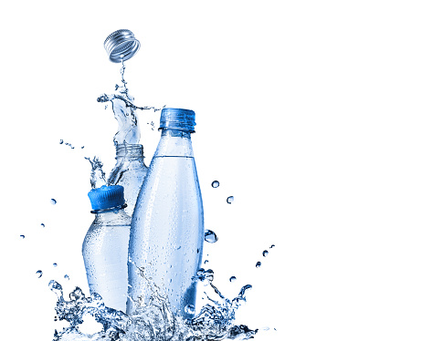 Drinking and mineral water in plastic bottles with splash around on white background