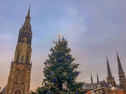 The towers of the New Church and the Maria van Jessekerk and a Christmas tree at the market in Delft