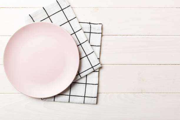 istock Top view on colored background empty round pink plate on tablecloth for food. Empty dish on napkin with space for your design 1505407224