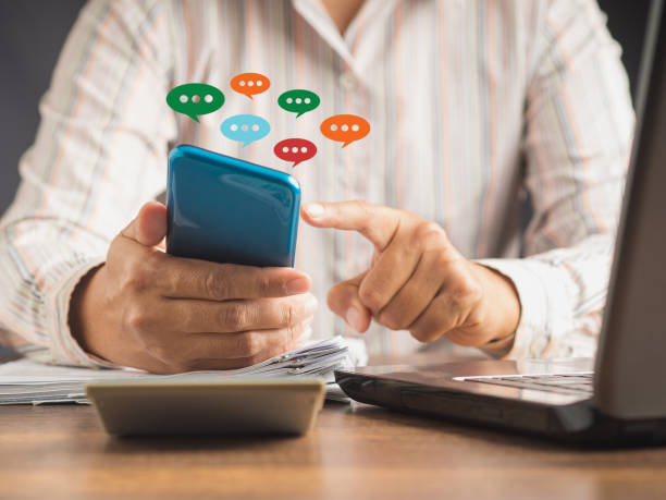 istock Close-up of hands using mobile phone with colorful chat icons on the application 1505415525