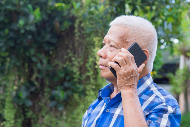 istock Senior man using a mobile phone while standing in the garden. 1505417121