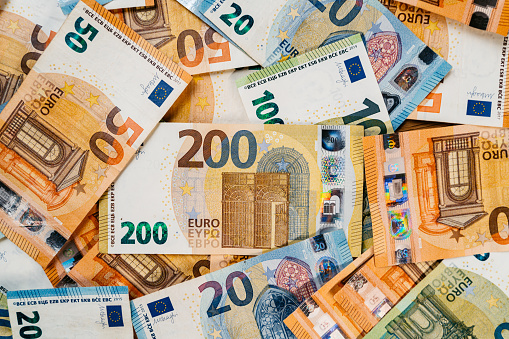 Heap of assorted colorful EURO bills laid down on a flat surface.