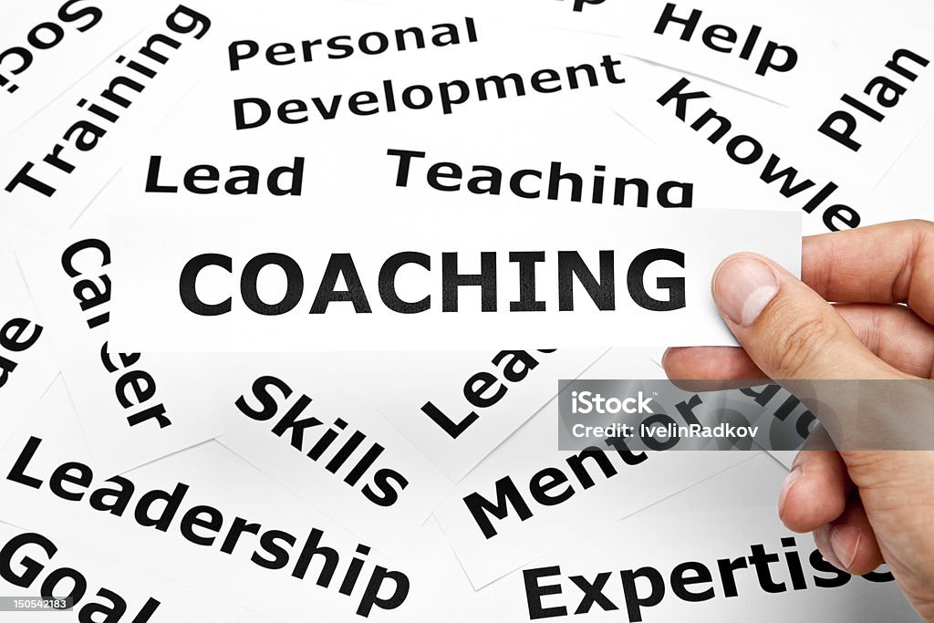 Coaching concept Hand holding a piece of paper with Coaching written on it. Adult Stock Photo