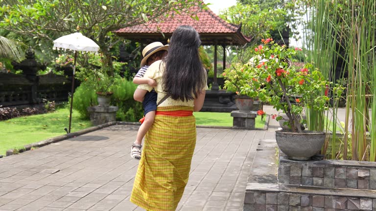 Young woman and her son in a Pura, Hinduism Bali temple