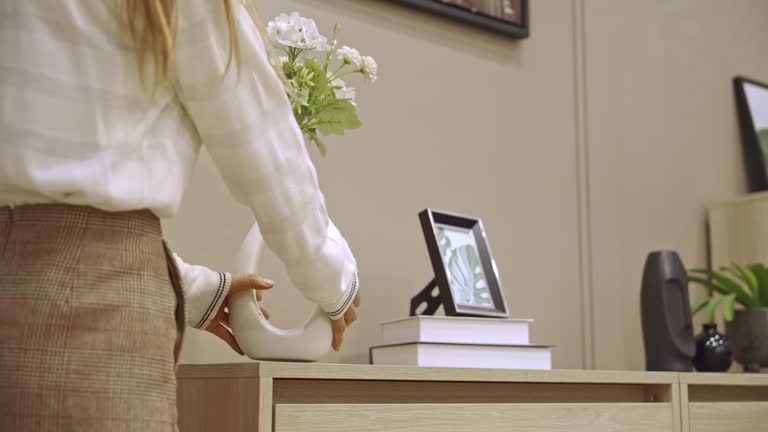 Asian woman placing a flower vase on the drawer