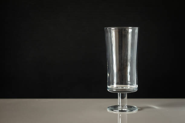 istock glass beaker on a leg with a black background on a white table 1505438647