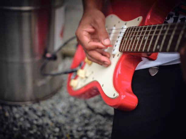 THE man indoors tuning guitar, front view and copy space.