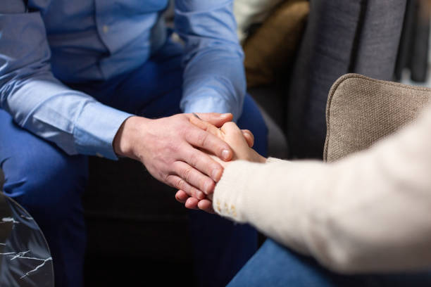 istock Man and woman hold hands sitting at psychologist session 1505449249