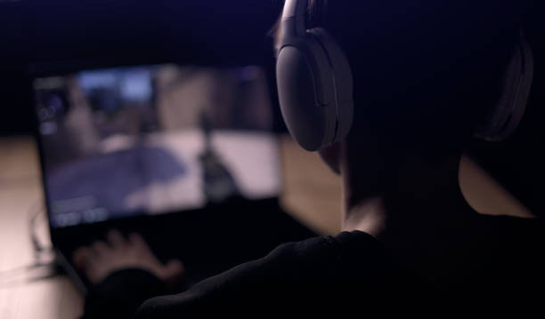 Young gamer is wearing a headset playing FPS video games at home. online video game technology concept. Teen boy play shooter video game on a mouse with a keyboard. Gambling addiction from video games Young gamer is wearing a headset playing FPS video games at home. online video game technology concept. Teen boy play shooter video game on a mouse with a keyboard.Gambling addiction from video games. spy games stock pictures, royalty-free photos & images