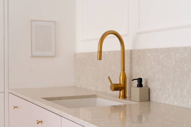 istock Kitchen interior with golden faucet and sink built into marble countertop 1505484220