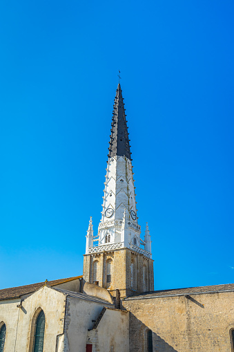 Bell tower of Saint-Etienne church in Ars-en-Ré, France a day of blue sky