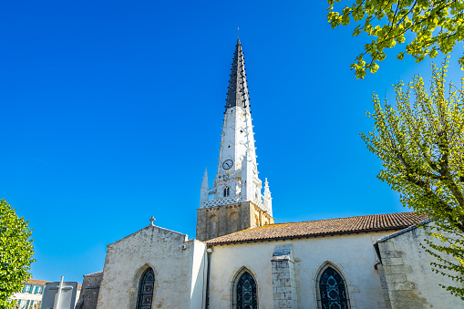 Church of Ars-en-Ré and its black and white bell tower in France on a sunny day