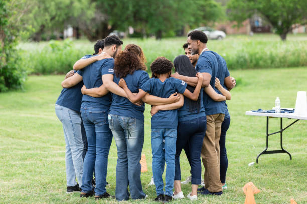 istock Volunteer group stands in a circle with their arms around each other 1505560720