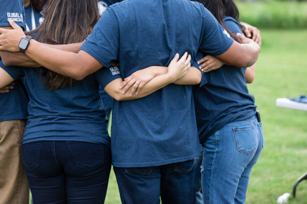 istock Unrecognizeable group of people stand close and embrace one another 1505560727