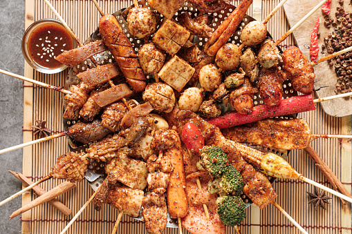 Group of Mala grilled barbecue stay in circle with Sichuan pepper, Hot and spicy and delicious street food in Thailand and ingredients food on bamboo placemat