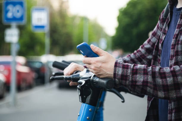 istock Close up of man hand using mobile app for rental electric scooter. 1505591482