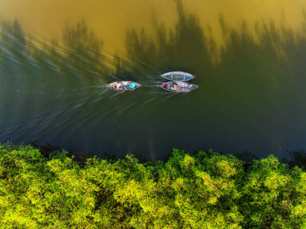 Drone view of a fishing boats is dragging another fishing boat moving on Quan Tuong river  - Nha Trang city, Khanh Hoa province, central Vietnam