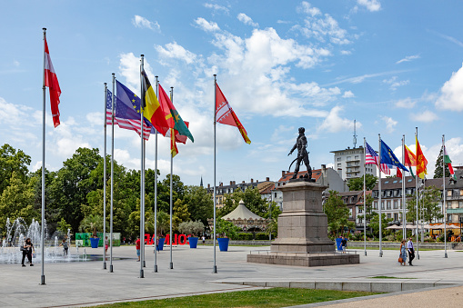 Colmar, France - June 21, 2023: statue of General Rapp at Rapp square with flags of the contries of the european union in Colmar, France