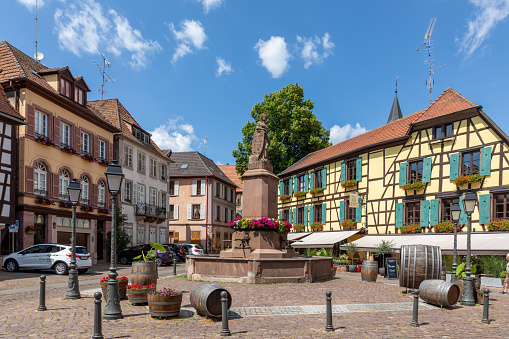 Ribeauville, France - June 23, 2023: A picturesque colorful street of half-timber buildings with shops and cafes in the village of Ribeauville, in the Alsace region.