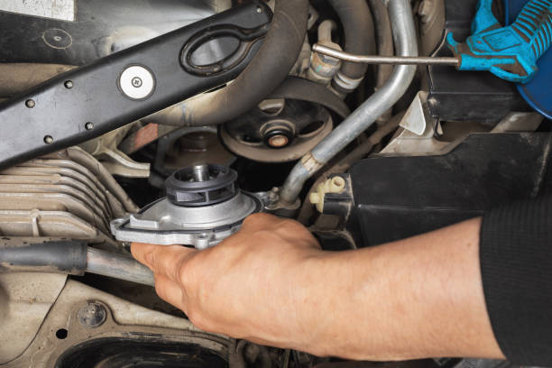 istock Auto mechanic installing a new engine cooling pump in a car at a service station 1505638213