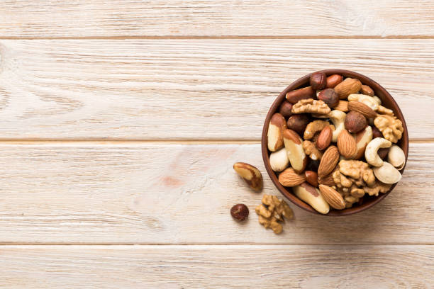 istock mixed nuts in bowl. Mix of various nuts on colored background. pistachios, cashews, walnuts, hazelnuts, peanuts and brazil nuts 1505641725
