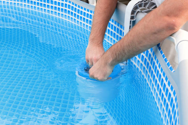 istock Man cleans skimmer for the frame pool. Contaminated pool cleaning concept 1505641795