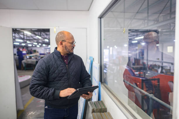 istock Manager monitoring progress in a warehouse looking through a window 1505641974