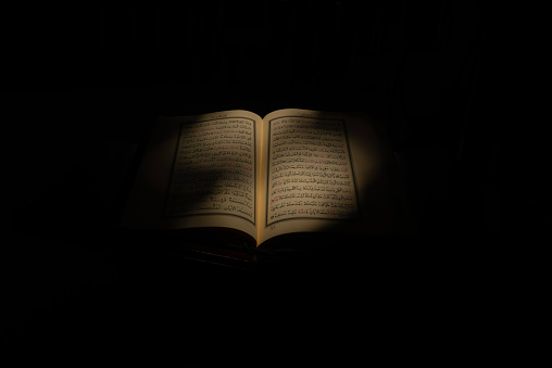 close-up of holy book Quran, sunlight is reflected to Quran