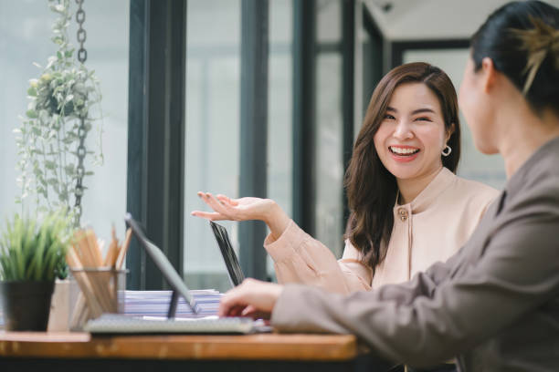istock Two professional millennial Asian startup businesspeople are discussing evaluation data in a conference room, focusing on growth and pointing to a financial account chart,graph. 1505662428
