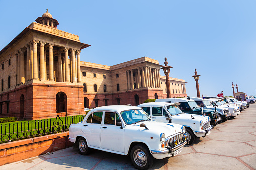 Delhi, India - November 17, 2011: AMBASSADOR car in front of indian parliament. the replica of Morris Oxforf model is still produced by HINDUSTAN MOTORS and standard for politicians.