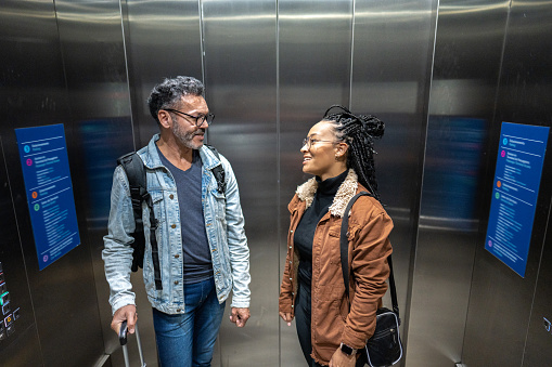 Friends talking in inside of elevator at the airport