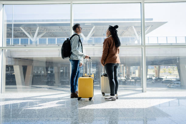 istock Friends looking through the window at the airport 1505710316