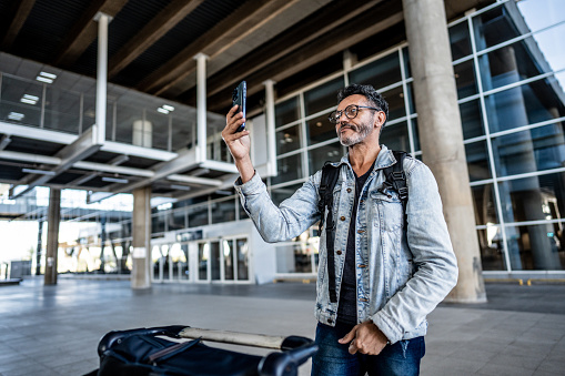Mature man using mobile phone at the airport