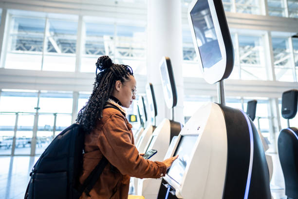 istock Young woman using self service check-in machine at the airport 1505727073