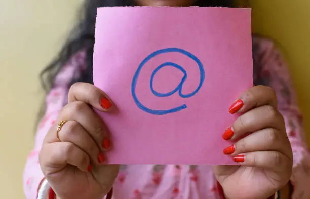 Photo of An Indian woman holding email picture icon in hand. Stop spam concept.