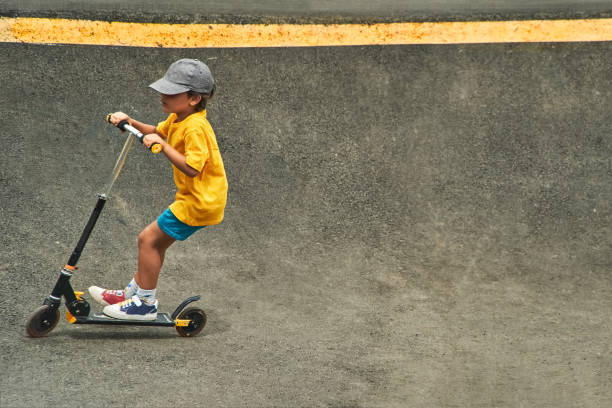 Boy riding scooter on a pumptrack turn