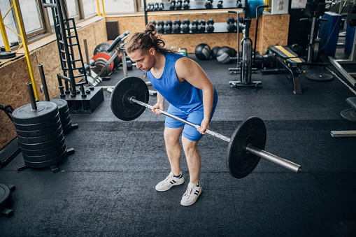 One man, fit male exercising with weights in gym.