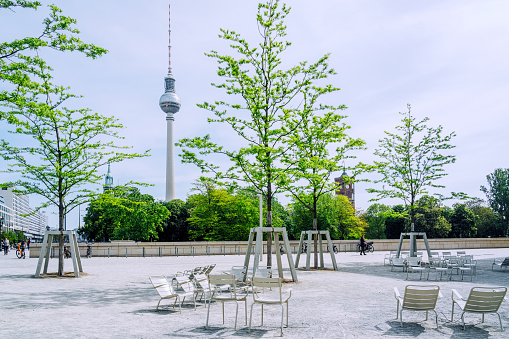 Empty chairs in central Berlin offer a serene setting with a sunny day view of the iconic Television Tower.
