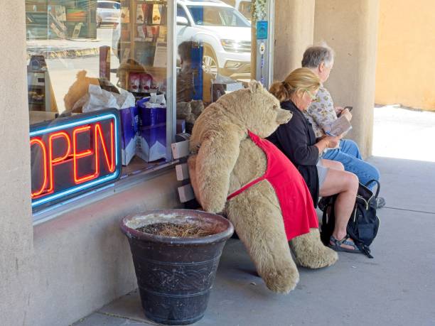 Taos, New Mexico - USA, May 12, 2023. Downtown Taos New Mexico. Plush bear a mascot in store front for and ice cream shop / eatery.