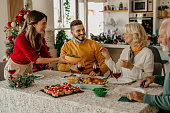 A festive feast awaits as a family eagerly gathers around the table, ready to indulge in a scrumptious Christmas lunch filled with seasonal delights.