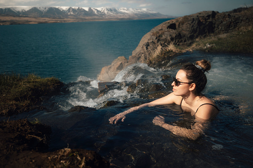 Woman relaxing in hot spring pool and enjoying the day