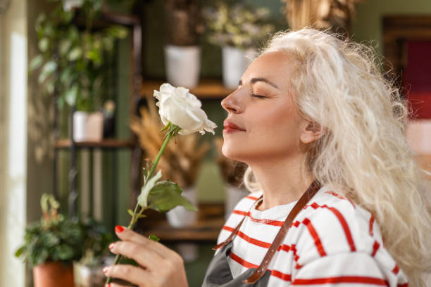 istock Flower shop worker smelling rose with eyes closed 1505858247