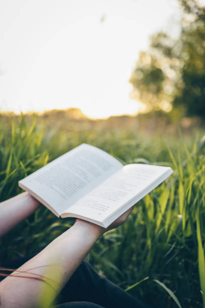 istock An open book in hands, the concept of nature, tranquility and solitude 1505865544