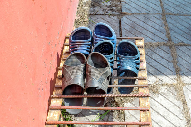 Old sandals ave drying outside on a metal grate