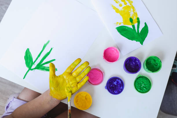 istock Children's art workshop, the child makes a handprint with paints 1505881321